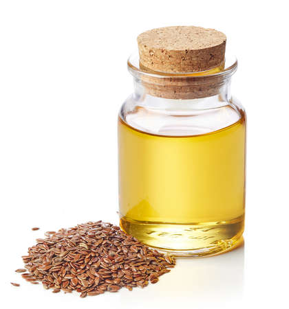 Bottle of linseed oil and linseeds isolated on white backgroundの写真素材
