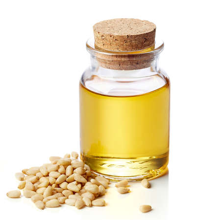 Bottle of pine nut oil and pine nuts isolated on white backgroundの写真素材