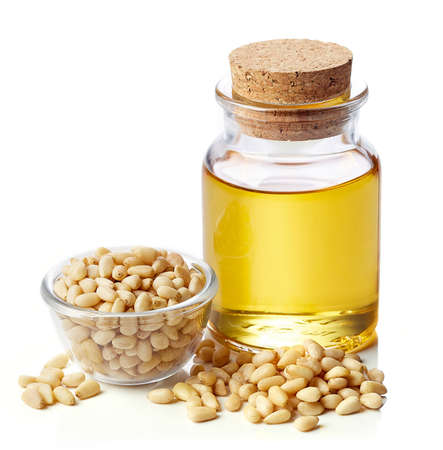 Bottle of pine nut oil and bowl of pine nuts isolated on white backgroundの写真素材