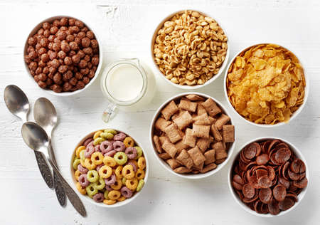 Bowls of various cereals and milk from top viewの写真素材