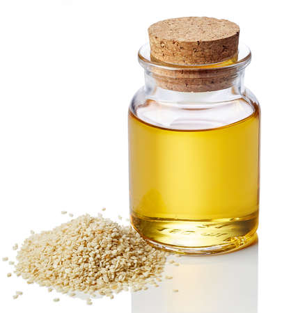 Bottle of sesame oil and sesame seeds isolated on white backgroundの写真素材