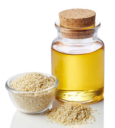 Bottle of sesame oil and sesame seeds isolated on white backgroundの写真素材