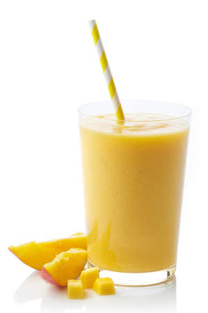 Glass of fresh healthy mango smoothie isolated on white backgroundの写真素材