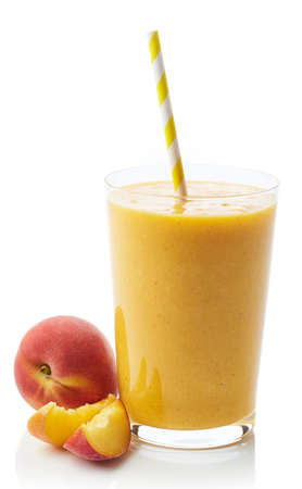 Glass of fresh healthy peach smoothie isolated on white backgroundの写真素材