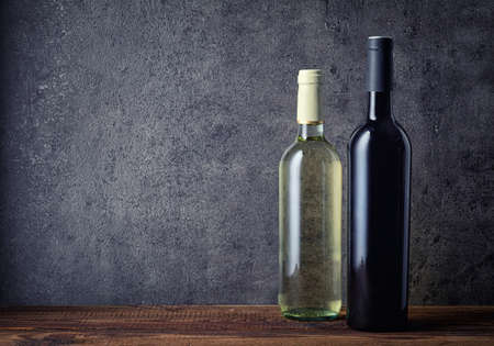 Bottle of red and white wine on dark background