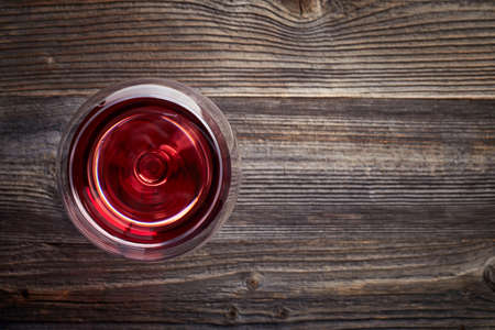 Glass of red wine on dark wooden background from top viewの写真素材
