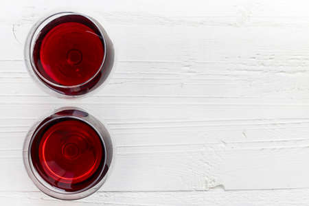 Two glasses of red wine on white wooden background from top viewの写真素材