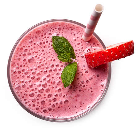 Glass of pink strawberry milkshake or cocktail isolated on white background. From top view