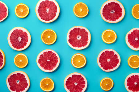 Colorful fruit pattern of fresh orange and grapefruit slices on blue background. From top viewの写真素材
