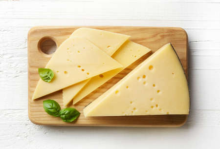 Cutting board of cheese on white wooden background. From top viewの写真素材