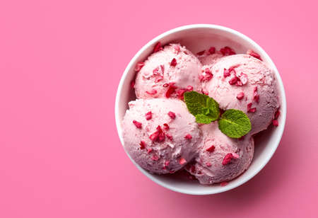 Bowl of pink strawberry ice cream isolated on pink background. Top viewの写真素材