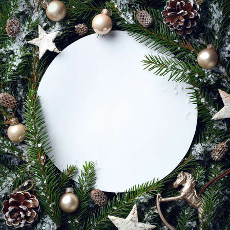 Creative frame of Christmas tree branches and decorations with round blank card. Top view. Xmas and New year concept