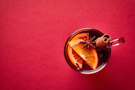 Hot mulled wine with spices on red background. Top viewの写真素材