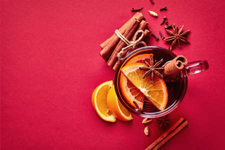 Hot mulled wine with spices on red background. Top viewの写真素材