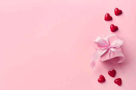Pink gift box and red hearts from top view. Valentines day concept.