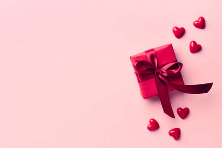 Red gift box on pink background. Top view. Valentines day concept. Space for textの写真素材
