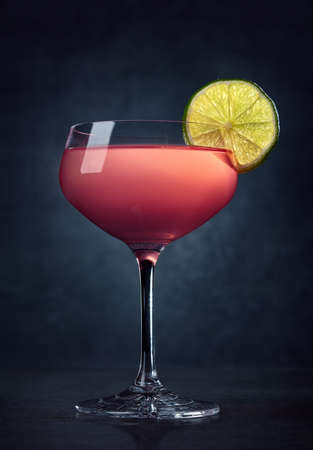 Glass of Cosmopolitan cocktail on dark backgroundの写真素材