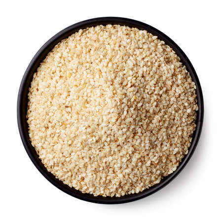 Black bowl of sesame seeds isolated on white background. Top viewの写真素材
