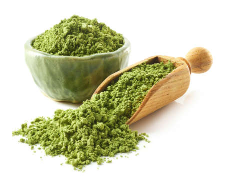 Scoop and bowl of green matcha tea powder isolated on white backgroundの写真素材