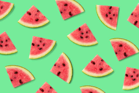 Colorful fruit pattern of watermelon slices on green background. Top view. Flat lay