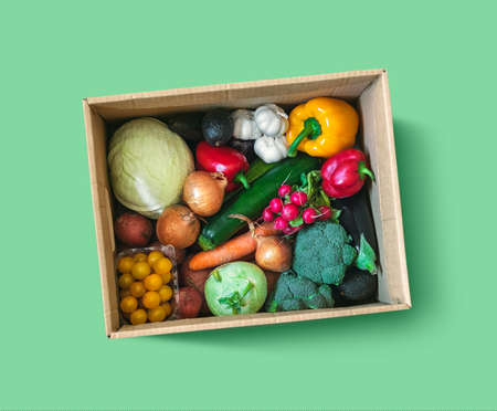 Fresh vegetable delivery box on green background, top viewの写真素材