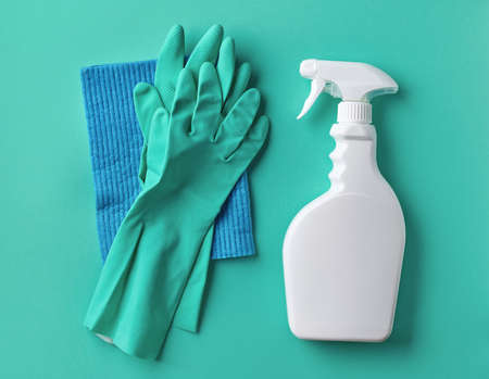 White spray bottle, rubber gloves and cleaning cloth on blue background, top viewの写真素材