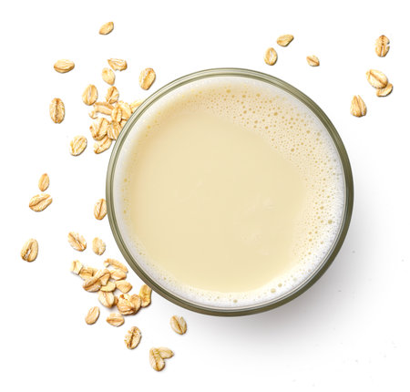 Glass of vegan oat milk isolated on white background, top view. Dairy free, plant based drink.の写真素材