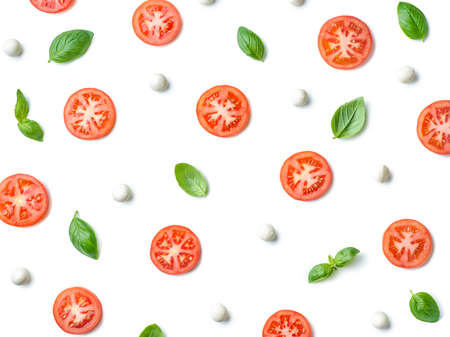 Pattern of fresh tomato slices, basil leaves and mozzarella cheese balls isolated on white...