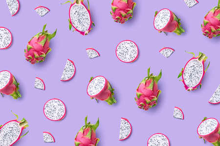 Pattern of fresh whole and sliced dragon fruit or pitahaya (pitaya)on purple background, top view, flat layの写真素材
