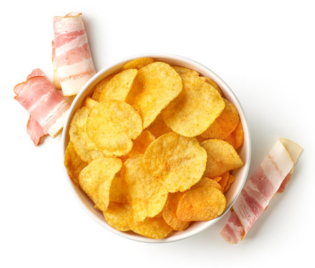 Bowl of crispy potato chips or crisps with bacon flavor isolated on white background, top viewの写真素材