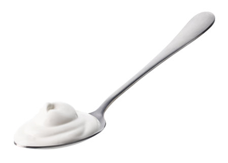 Silver spoon of fresh greek yogurt isolated on white backgroundの写真素材