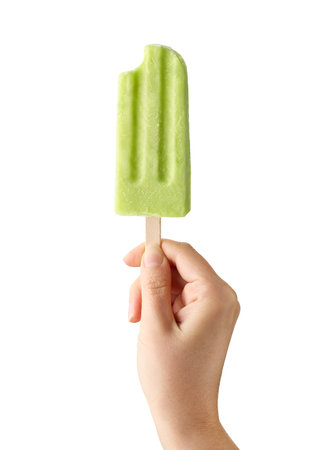 Woman hand holding bitten green fruit isolated on white background. Apple, lime and pear flavorの写真素材