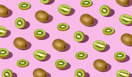 Colorful pattern of fresh ripe whole and sliced kiwi fruits. Minimal trendy sunlight fruit conceptの写真素材