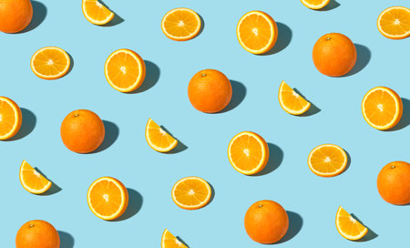 Colorful pattern of fresh ripe whole and sliced oranges. Minimal trendy sunlight fruit conceptの写真素材