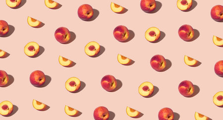 Colorful pattern of fresh ripe whole and sliced peaches. Minimal trendy sunlight fruit concept on light peach backgroundの写真素材