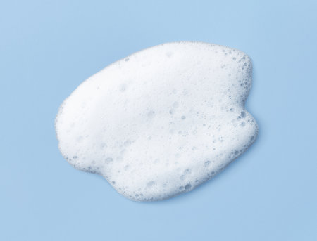 White skincare cleansing foam on light blue background. Soap, shampoo or shower gel foam texture, close-up, top viewの写真素材