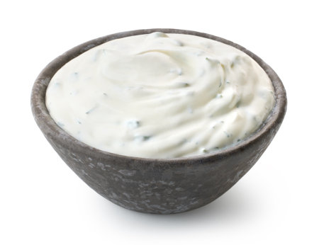 Dark grey ceramic bowl of fresh sour cream dip sauce with herbs isolated on white backgroundの写真素材