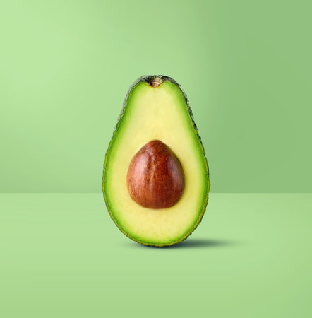 Half of fresh green avocado on pastel green backgroundの写真素材