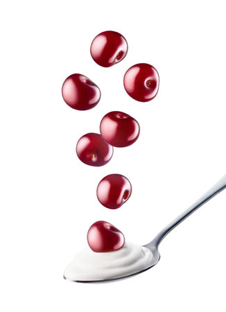 Spoon of fresh greek yogurt and falling cherries isolated on white backgroundの写真素材