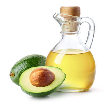 Bottle of avocado oil and fresh avocado halves isolated on white backgroundの写真素材