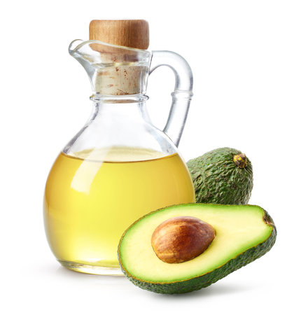 Bottle of avocado oil and fresh avocado halves isolated on white backgroundの写真素材