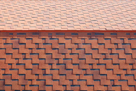The texture of the roof with bituminous coating. Rough bituminous mosaic of red and brown flowers....