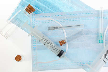 Medical protective mask with syringes on a white background. Corona virus. Healthcare and medical concept. close view of medical surgical flu disease face protection masks textile filterの写真素材