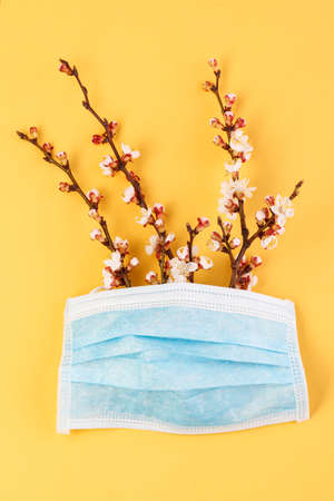 The concept of comparing prevention and health with spring in nature. Means of preventing viral diseases. Medical mask gloves on a yellow background.の写真素材