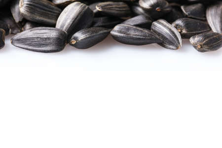 Black, natural, roast sunflower seeds isolated on white background. For texture or background.の写真素材