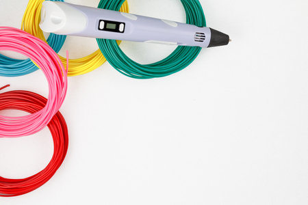Top view on 3d pen, kit of colorful PLA or ABS plastic filament on white background. close up