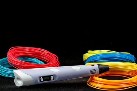 3d pen, and kit of colorful PLA or ABS plastic filament on black background. close upの写真素材