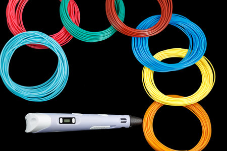 3d pen, and kit of colorful PLA or ABS plastic filament on black background. close up