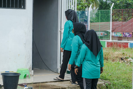 Unidentified Muslim women cleaning the street. women are entering a room.の写真素材