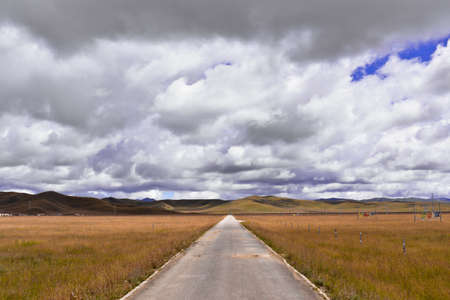 Clouds in the sky with roadway at meadowの写真素材